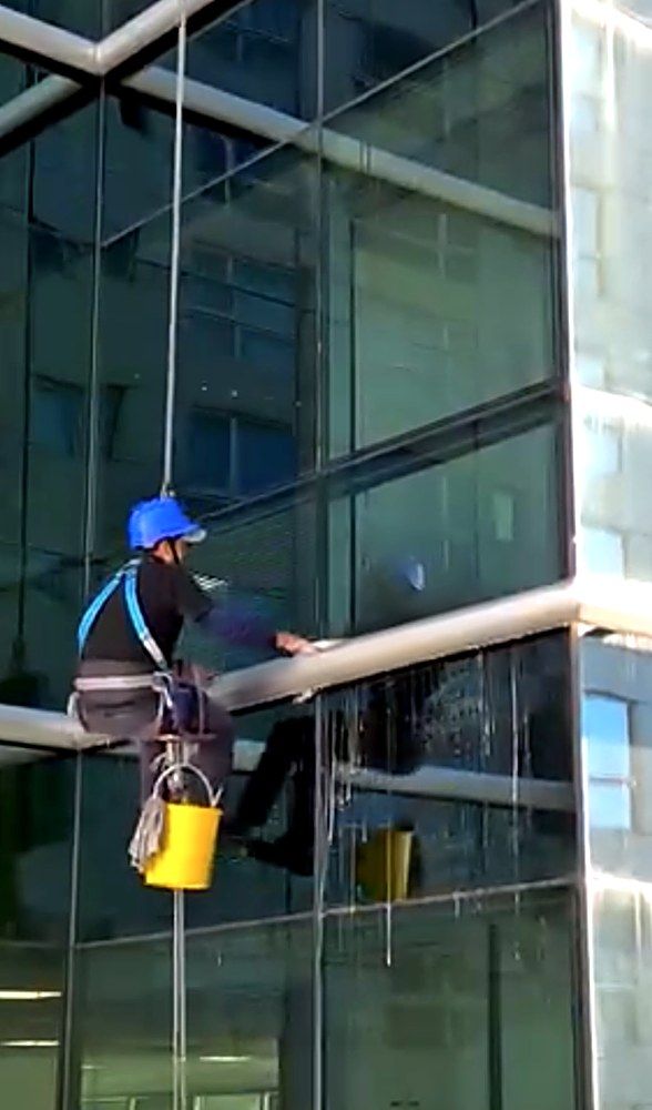 Silletero de Crystal limpiando la fachada vidriada de un edificio